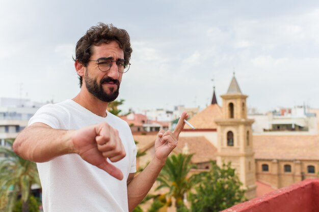 Joven barbudo fumando un cigarrillo