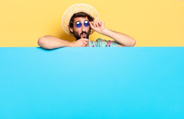 Joven barbudo con gafas de sol y tablero azul