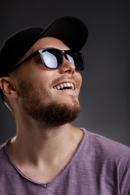 Joven barbudo con gorra y gafas de sol