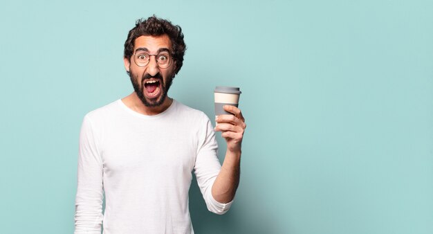 Joven barbudo loco con un café para llevar