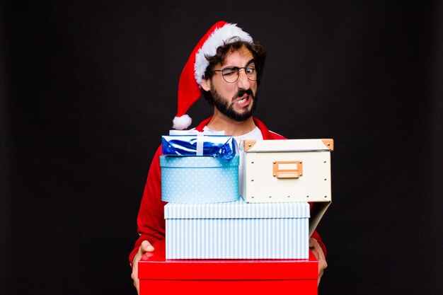 Joven barbudo loco con sombrero de santa. Concepto de navidad