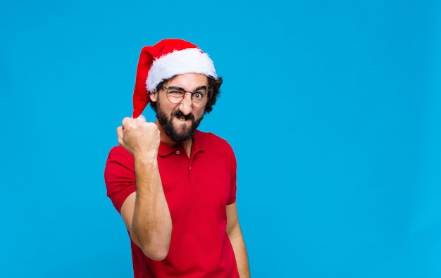 Joven barbudo loco con sombrero de santa. Concepto de navidad