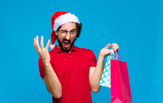 Joven barbudo loco con sombrero de santa. Concepto de navidad