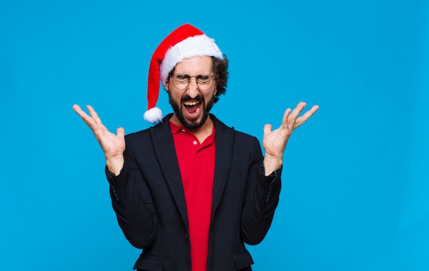 Joven barbudo loco con sombrero de santa. Concepto de navidad