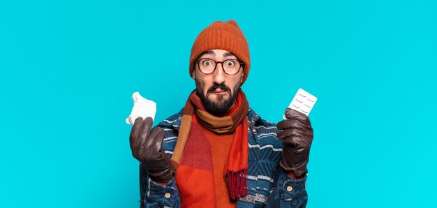 Joven barbudo loco y vistiendo ropa de invierno. concepto de enfermedad