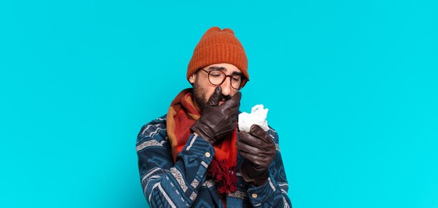 Joven barbudo loco y vistiendo ropa de invierno. concepto de enfermedad