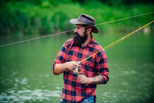 Joven barbudo pescando en un lago o río