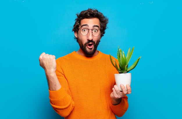 Joven barbudo con una planta de cactus