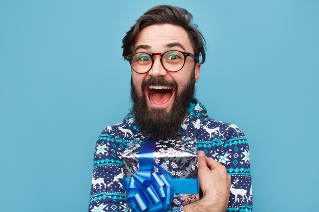 Foto joven barbudo con regalo azul envuelto