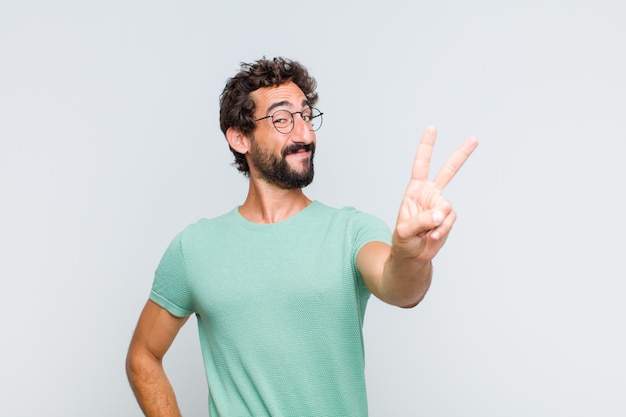 Joven barbudo sonriendo y mirando feliz