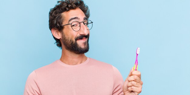 Joven barbudo sonriendo, sintiéndose seguro, exitoso y feliz, mostrando concepto o idea en el espacio de la copia en el lateral