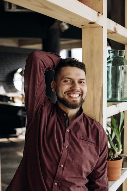 Joven barbudo sonriendo en su apartamento