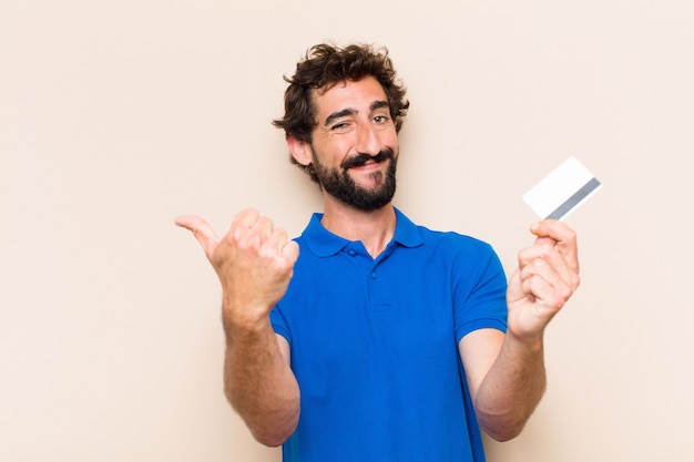 Joven barbudo con tarjeta de crédito