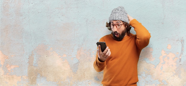 Joven barbudo con un teléfono inteligente