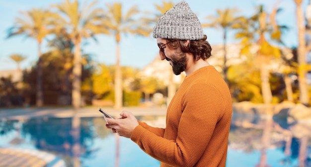 Joven barbudo con un teléfono inteligente