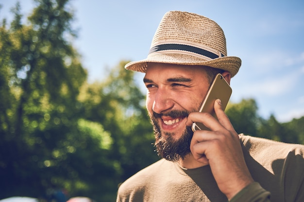 Joven barbudo con un teléfono inteligente