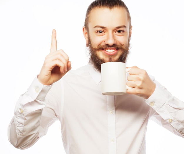 Foto joven barbudo tomando café y mostrando el pulgar hacia arriba.