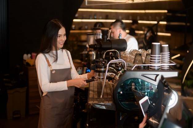 Una joven barista que trabaja en una cafetería moderna