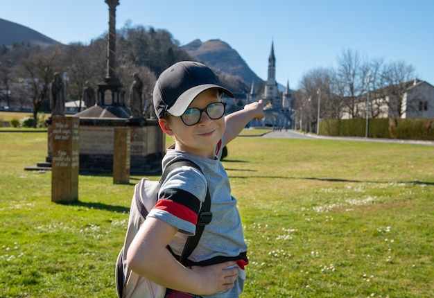 Joven con la basílica de Lourdes en Francia