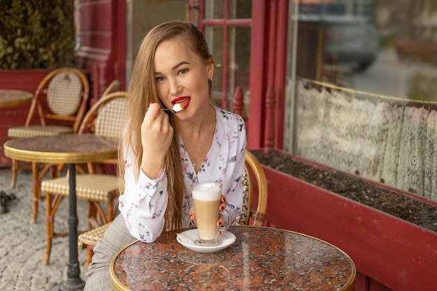 Joven bebiendo café en un café parisino de la calle