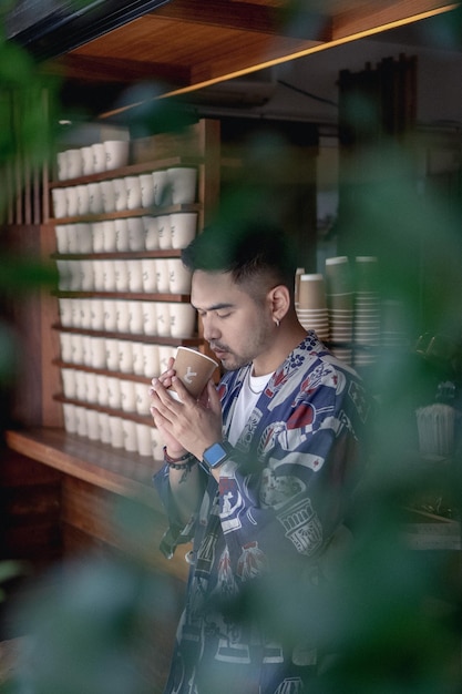 Foto un joven bebiendo café en una taza.