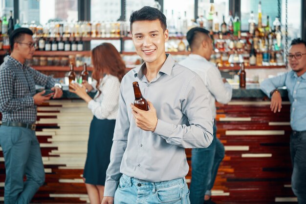 Joven bebiendo cerveza en el bar