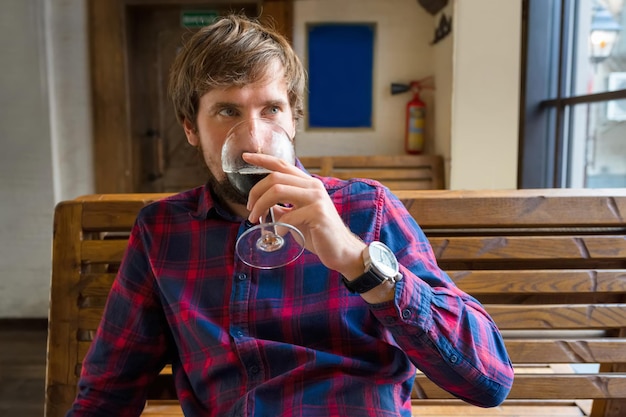 Joven bebiendo cerveza solo en un bar