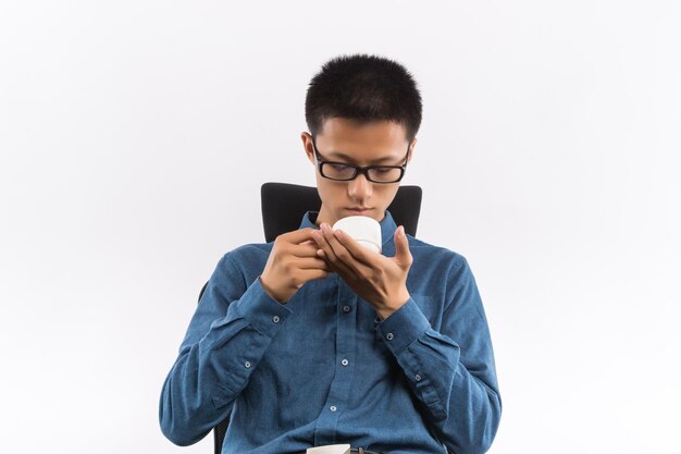 Joven bebiendo taza de porcelana de té natural asiático