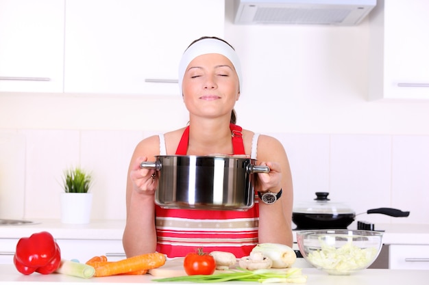 Una joven y bella esposa que trabaja en una cocina moderna.