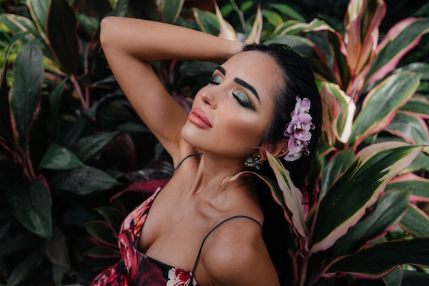 Foto una joven y bella morena posando entre densos matorrales de selva y selva. spa