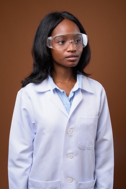 Joven y bella mujer africana zulú médico con gafas protectoras