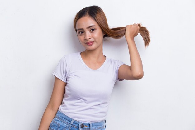 Joven y bella mujer asiática con un cabello fuerte y saludable aislado sobre fondo blanco.