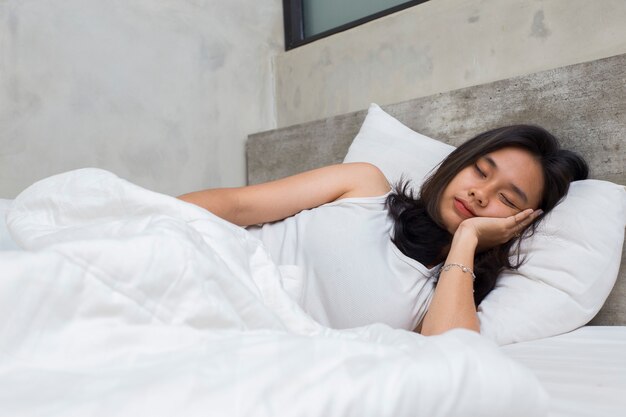 joven y bella mujer asiática durmiendo en el dormitorio