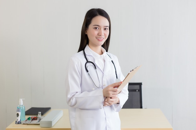 Joven y bella mujer asiática médico que trabaja en el hospital Ella usa una bata blanca y un estetoscopio