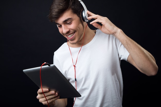 Joven y bella mujer escuchando música. Aislado en negro.