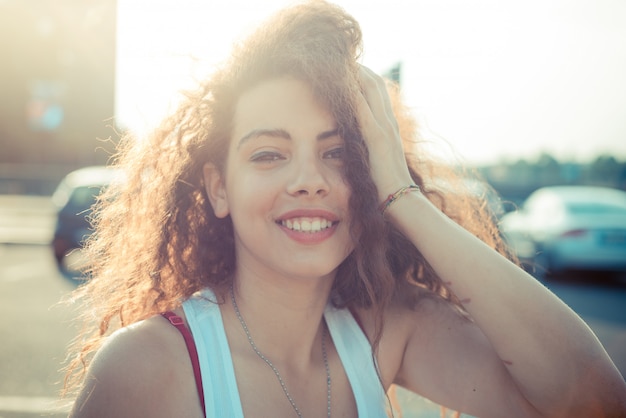 joven y bella mujer de hipster de pelo largo y rizado