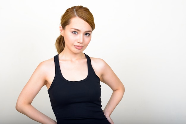 Joven y bella mujer japonesa contra la pared blanca