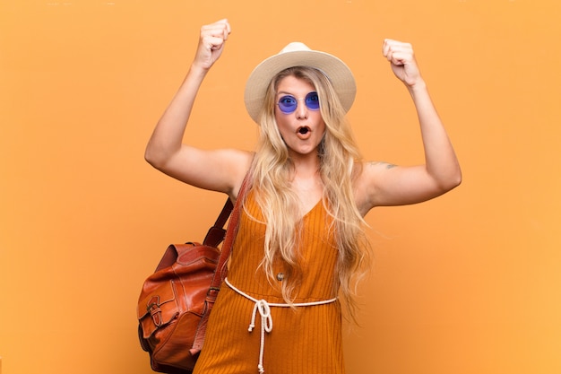 Joven y bella mujer latina celebrando un éxito increíble como un ganador, con expresión emocionada y feliz diciendo ¡tómalo !. concepto turistico