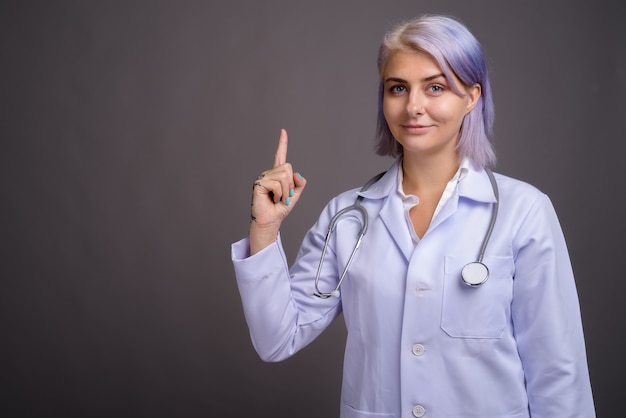 Joven y bella mujer médico con pelo corto de colores