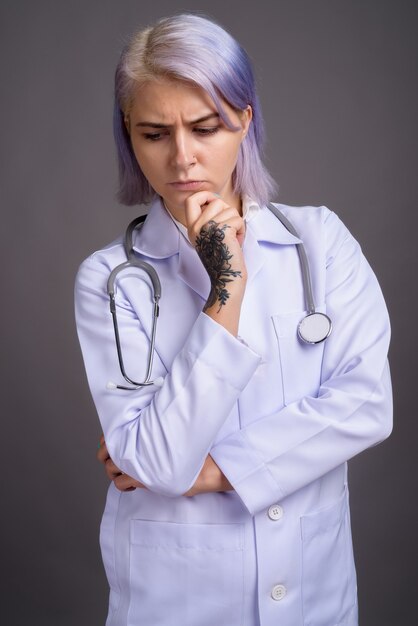 Joven y bella mujer médico con pelo corto de colores