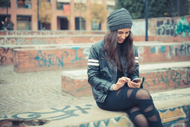 joven y bella mujer morena con smartphone