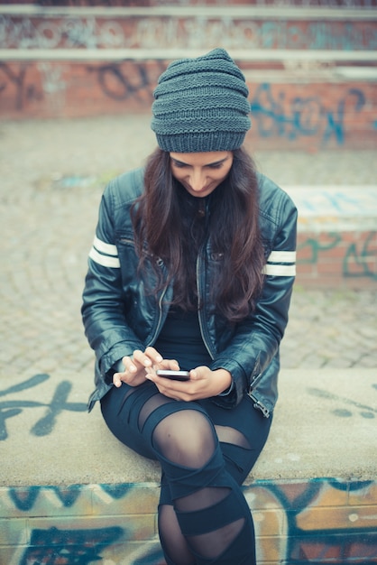 joven y bella mujer morena con smartphone