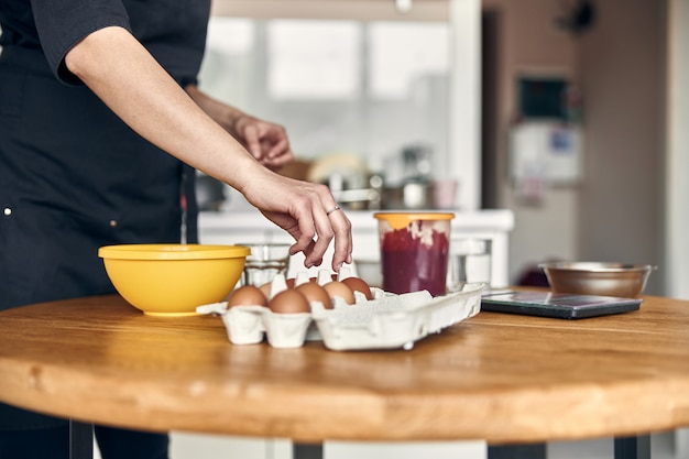 Foto joven y bella mujer de raza mixta está preparando malvavisco en casa de cocina moderna luz