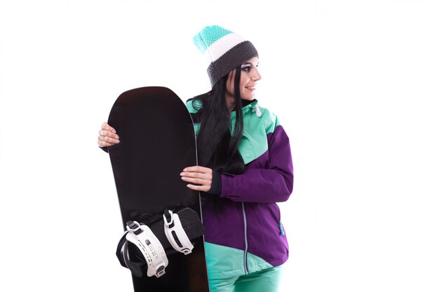 joven y bella mujer en traje de esquí púrpura mantenga snowboard