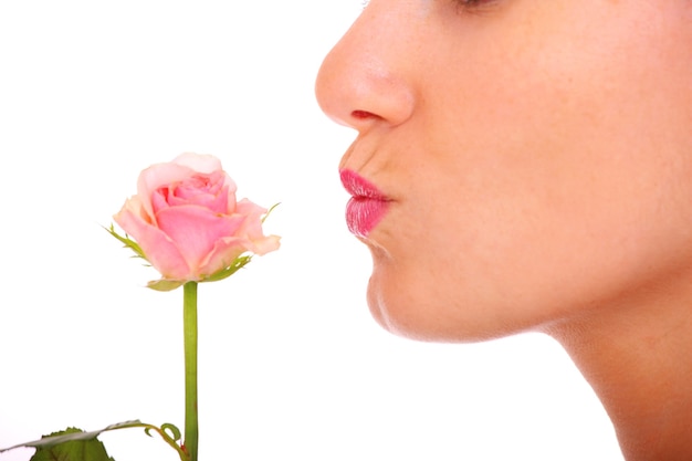 Una joven besando una rosa sobre fondo blanco.