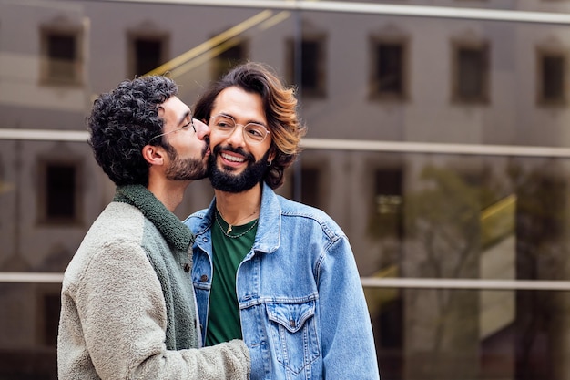 Joven besando a su novio en la mejilla