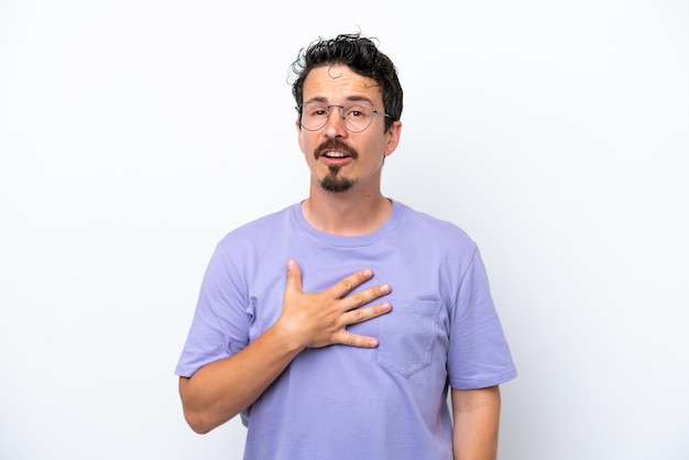 Joven con bigote aislado en fondo blanco señalándose a sí mismo