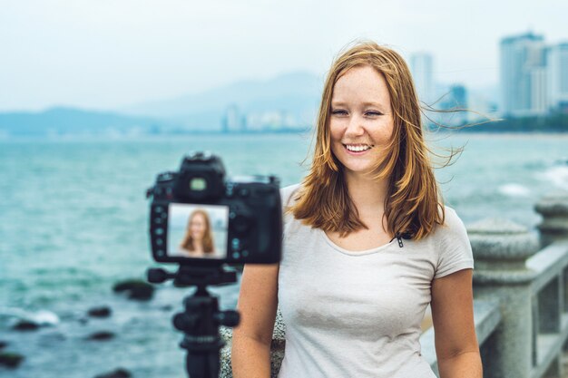 Joven blogger filmando junto al mar