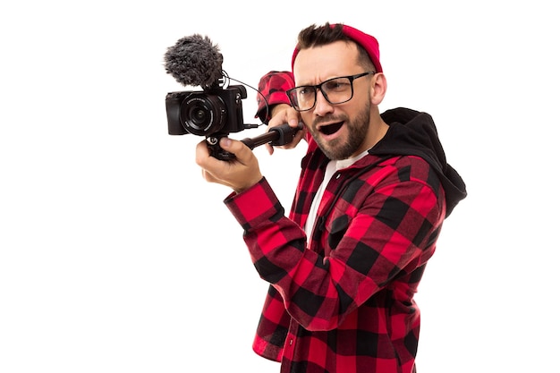 Joven blogger masculino filmando una historia en una cámara de video con un micrófono