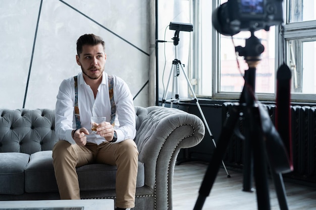 Joven blogger de sexo masculino grabando video en casa.